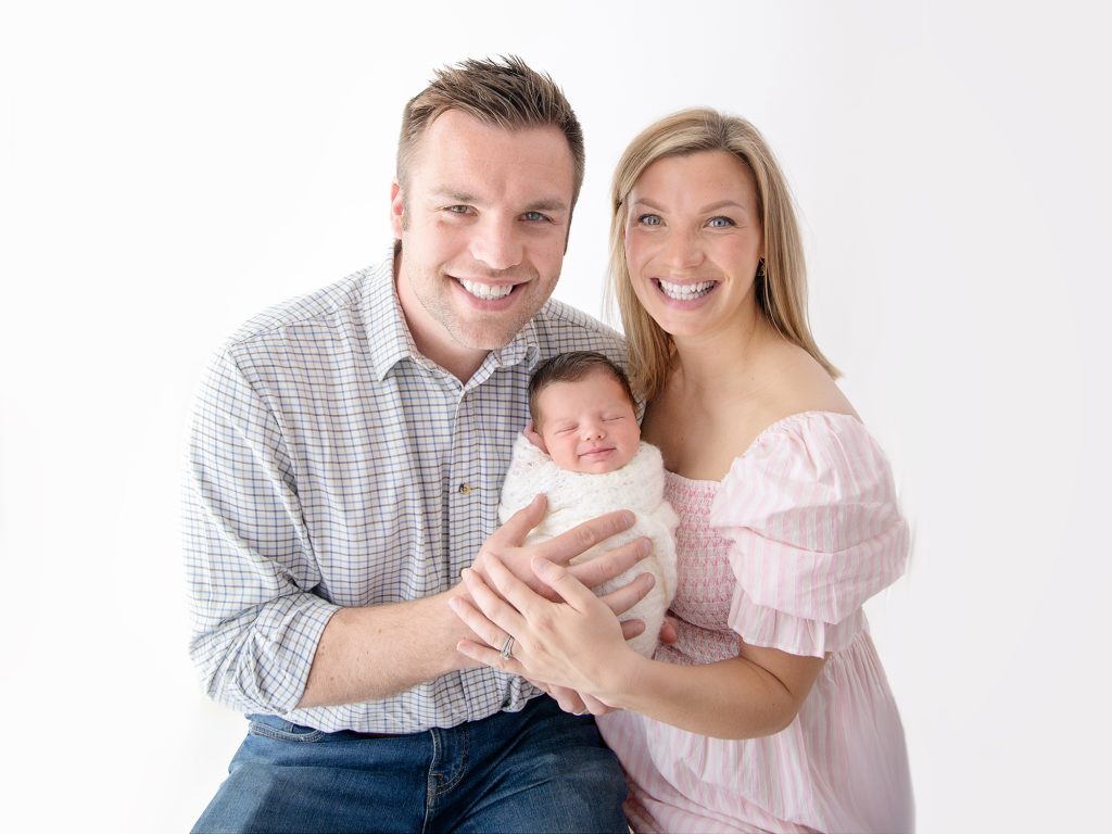 mum and dad with newborn baby posing ideas studio white background