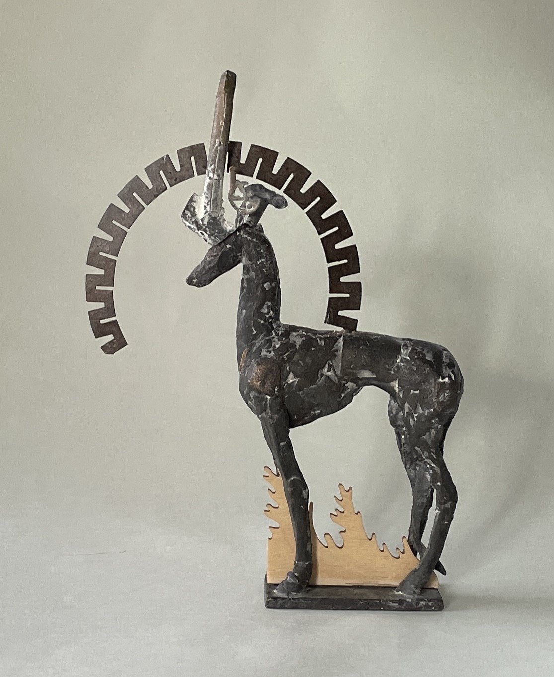 "Hirsch mit Kranz", Materialcollage aus Bronze, Eisen, Holz, 23,5 x 17 x 3,5 cm. 2023
