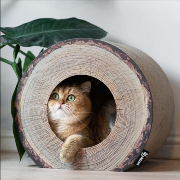 Een kat zit in het krabmeubel TRUNK van District70 is geïnspireerd op de vorm van een boomstam.