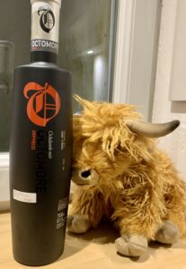 Eine Flasche Octomore 02.2 Orpheus und ein Hochlandrindplüschtier