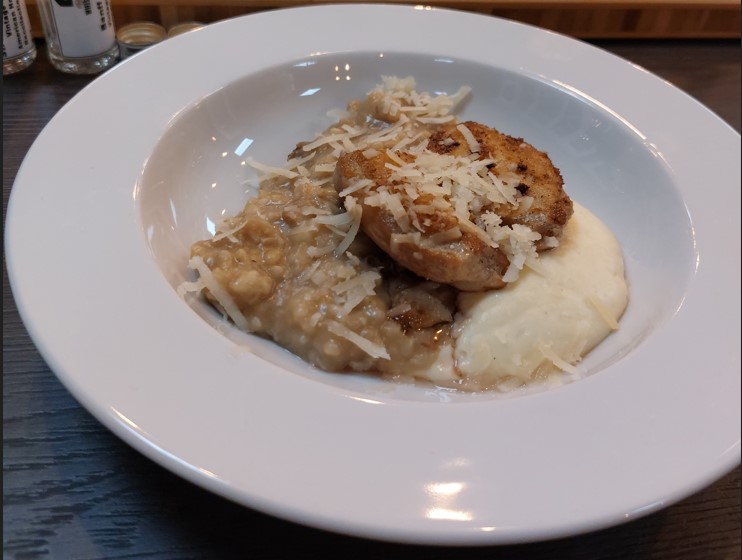 Auf dem Bild ist eines der Gerichte, das Steinpilzrisotto mit Wachtelbrust und Parmesan-Espuma, zu sehen.