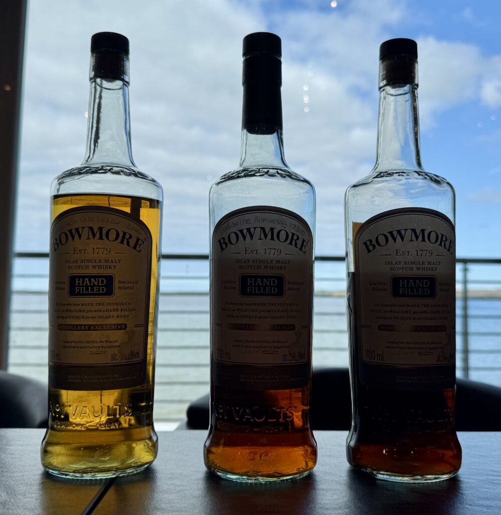 Drei Bowmore handfilled fotografiert mit Blick aus dem Fenster im Besucherzentrum Richtung Meer