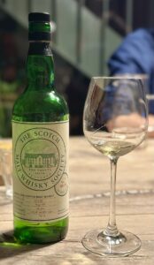 Eine Flasche St. Magdalene 1982 neben einem Weißweinglas