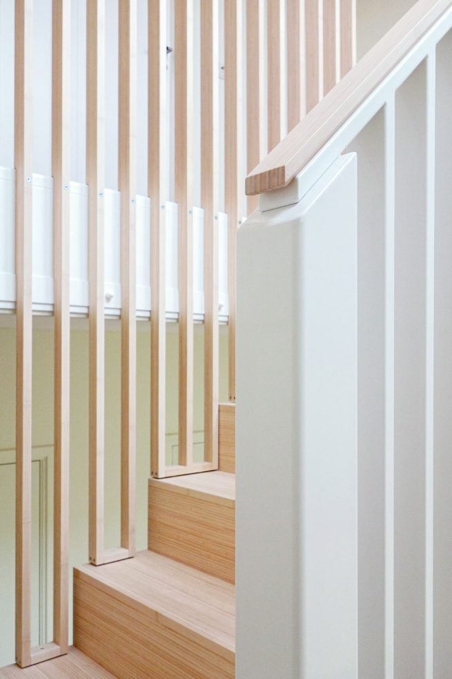 Maatwerk stalen trap met bamboe treden en een strakke balustrade met verticale elementen