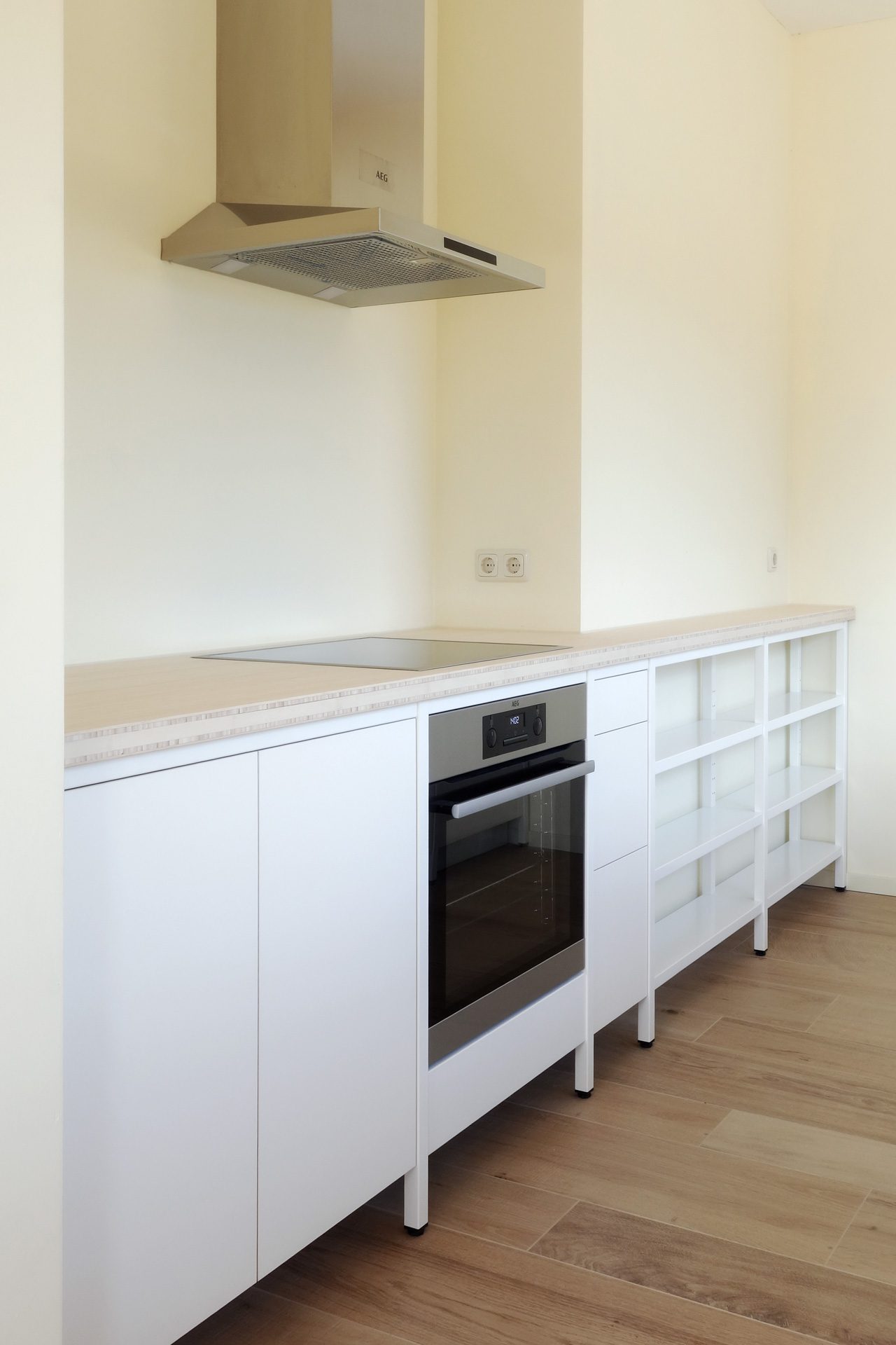 industriele-witte-keuken-staal-bamboe-frame Overzicht van de witte stalen keuken met inbouwapparatuur, inductiekookplaat, oven, spoelbak en open legplanken