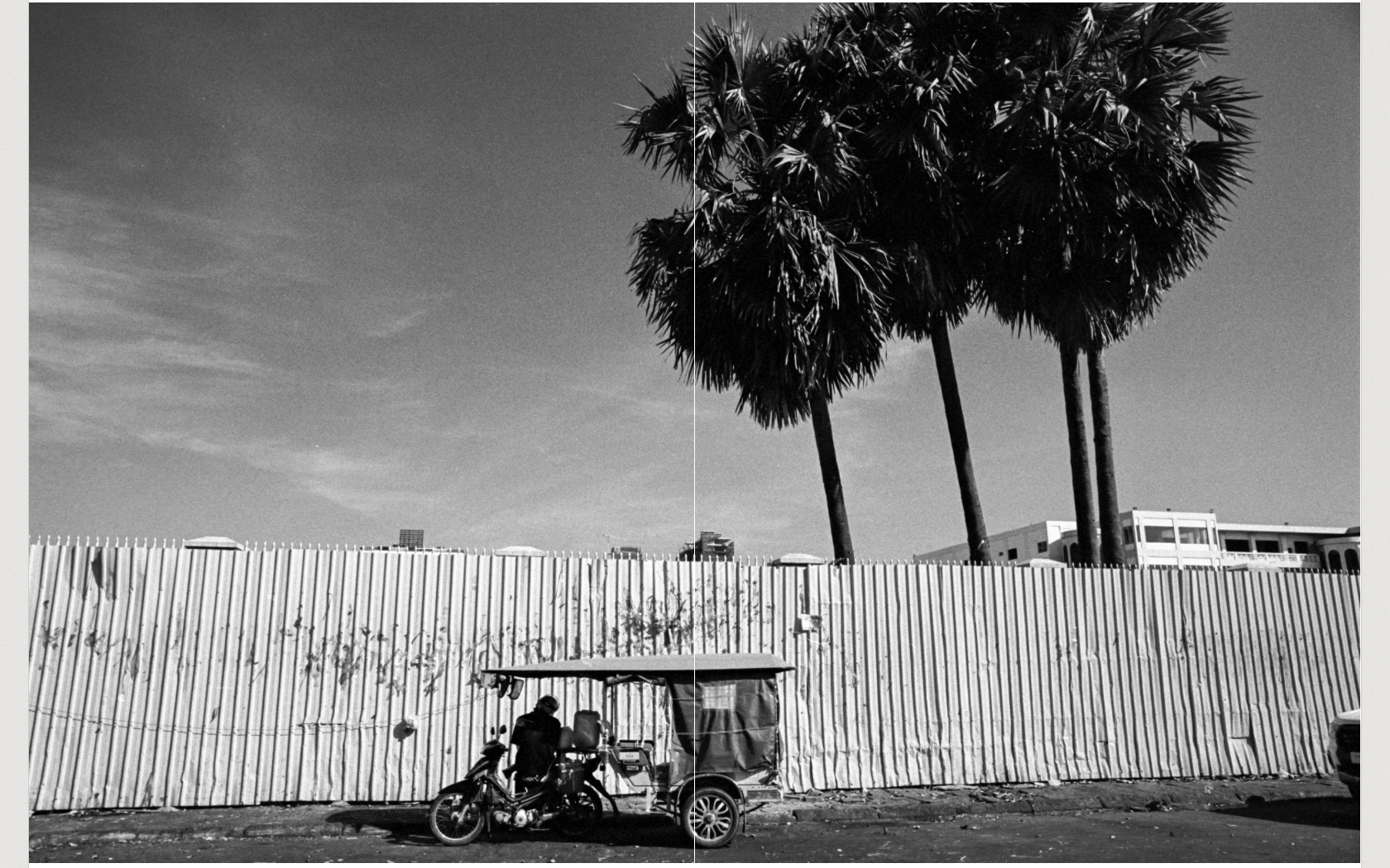 Phnom Penh street scene with tuk tuk and palm trees