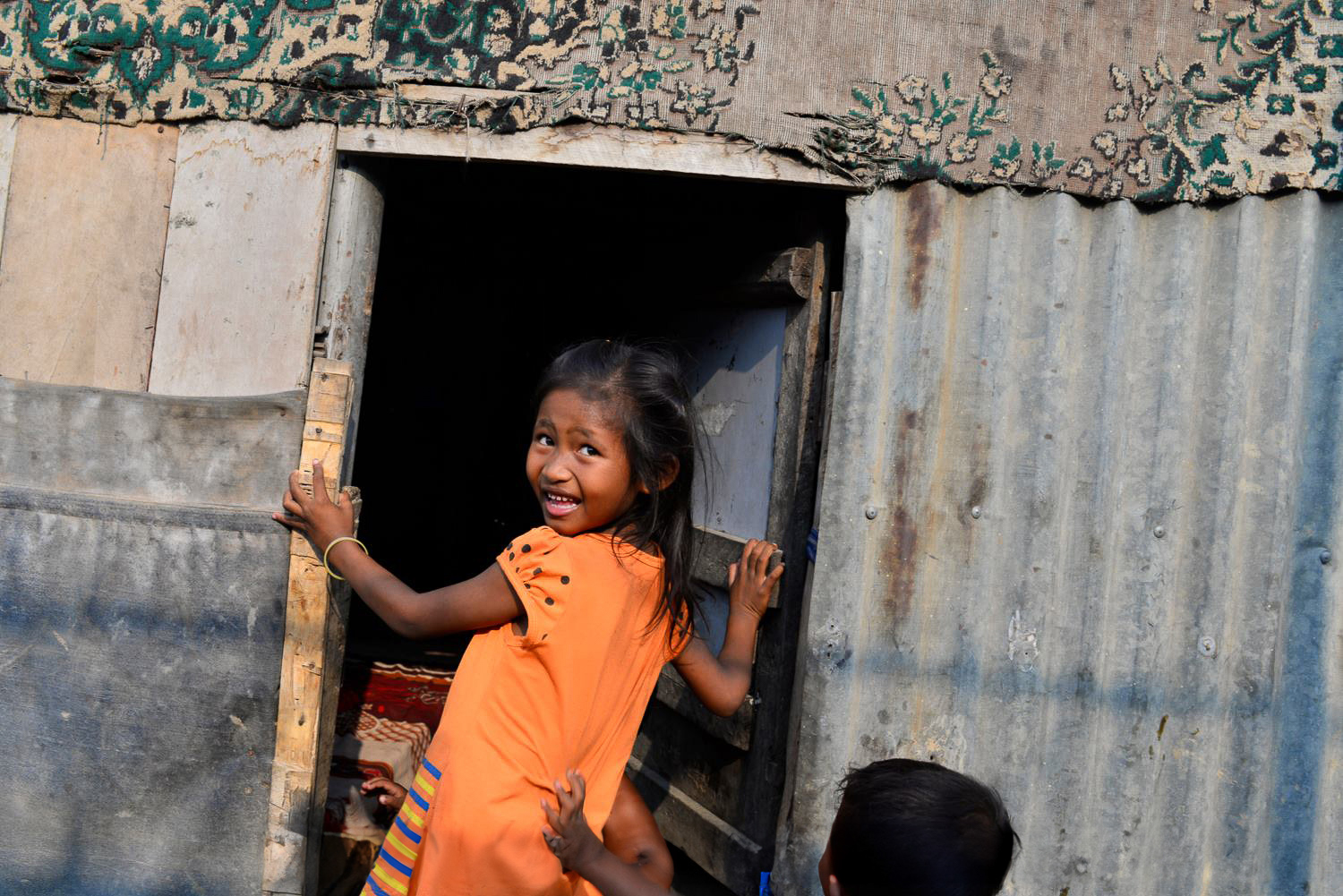 Cambodia Photo Tours -young girl in the doorway Phnom Penh slums