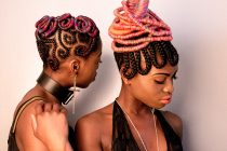black and white photo of two black models in colorful intricate braids and vintage fashion