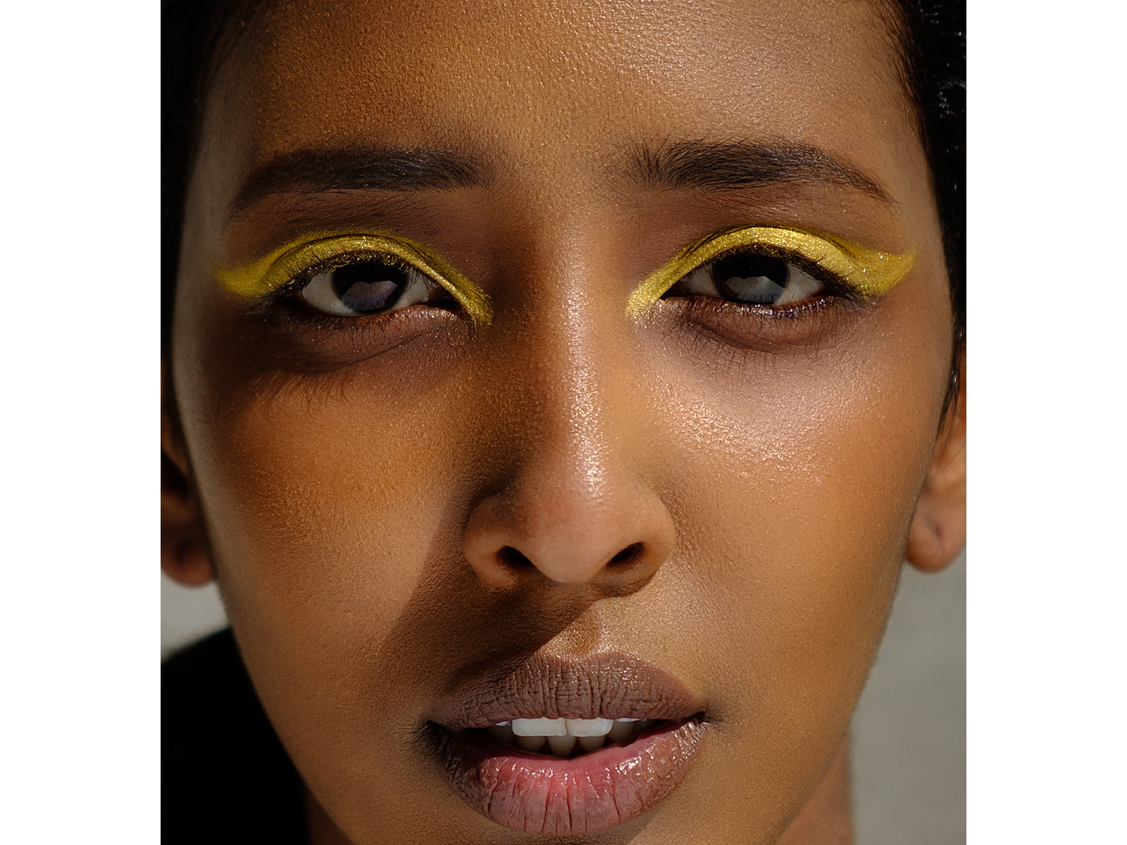 closeup beauty shot of black model in yellow eye shadow