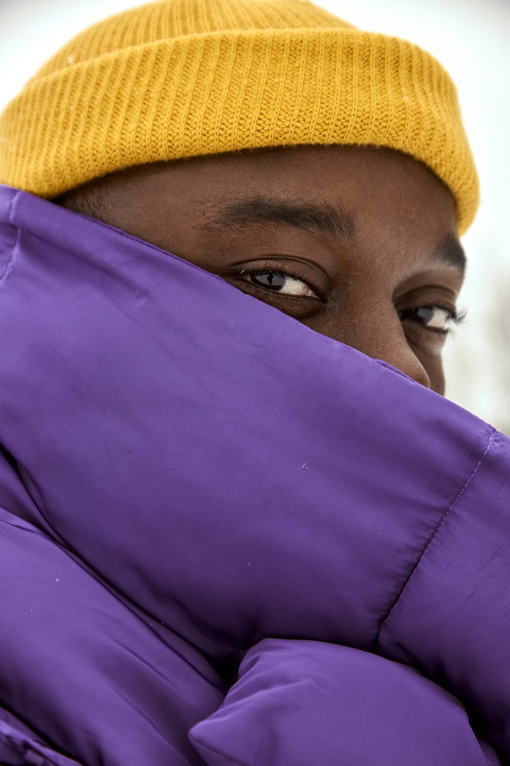 purple puffer coat with yellow hat