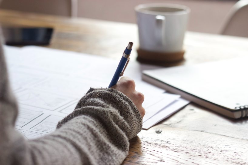 Mujer escribiendo en una agenda para ahorrar dinero boda