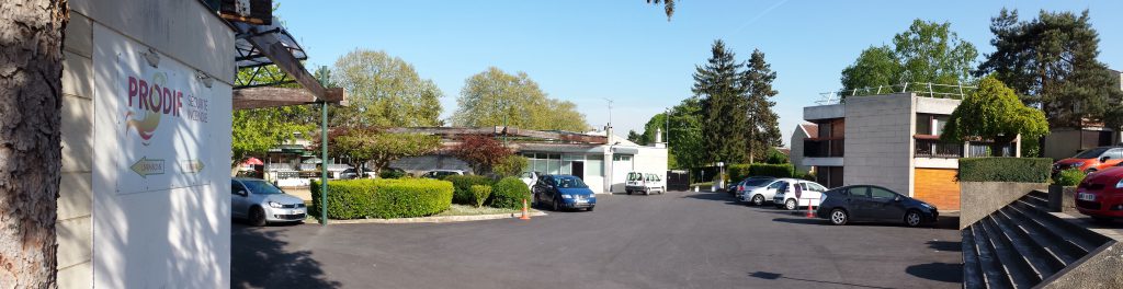 Panoramique sur le centre commercial, et la loge du gardien des Hameaux de la Roche