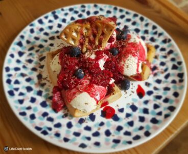 waffles on a plate with berries and ice cream