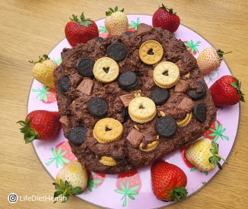 chocolate brownie on a serving dish with fresh multicoloured strawberries
