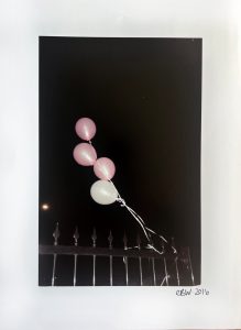 pink balloons tied to rail