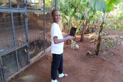 Toni mit seinem ersten kleinen Laptop vor dem Hühnerstall