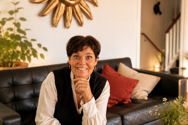 Ann sitter i sin soffa med vacker inredning.