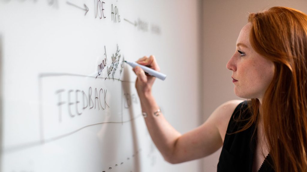 Woman writing on whiteboard