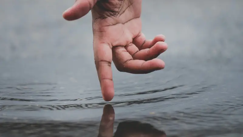 Hand creates ripples in the water