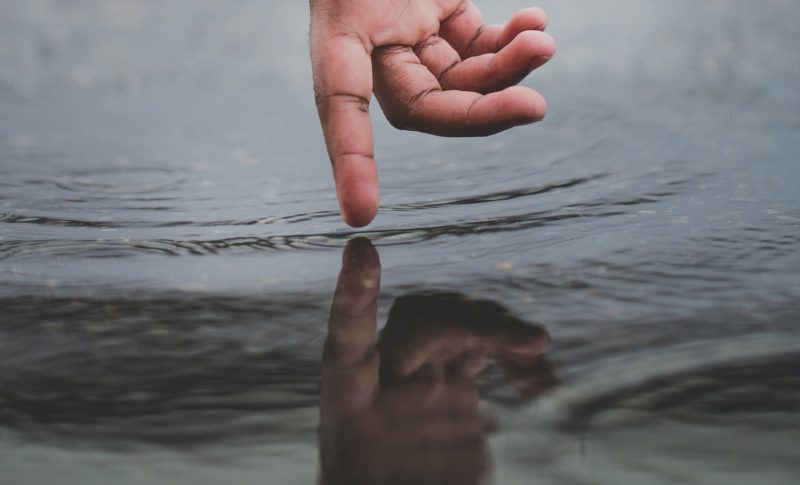 Hand creates ripples in the water