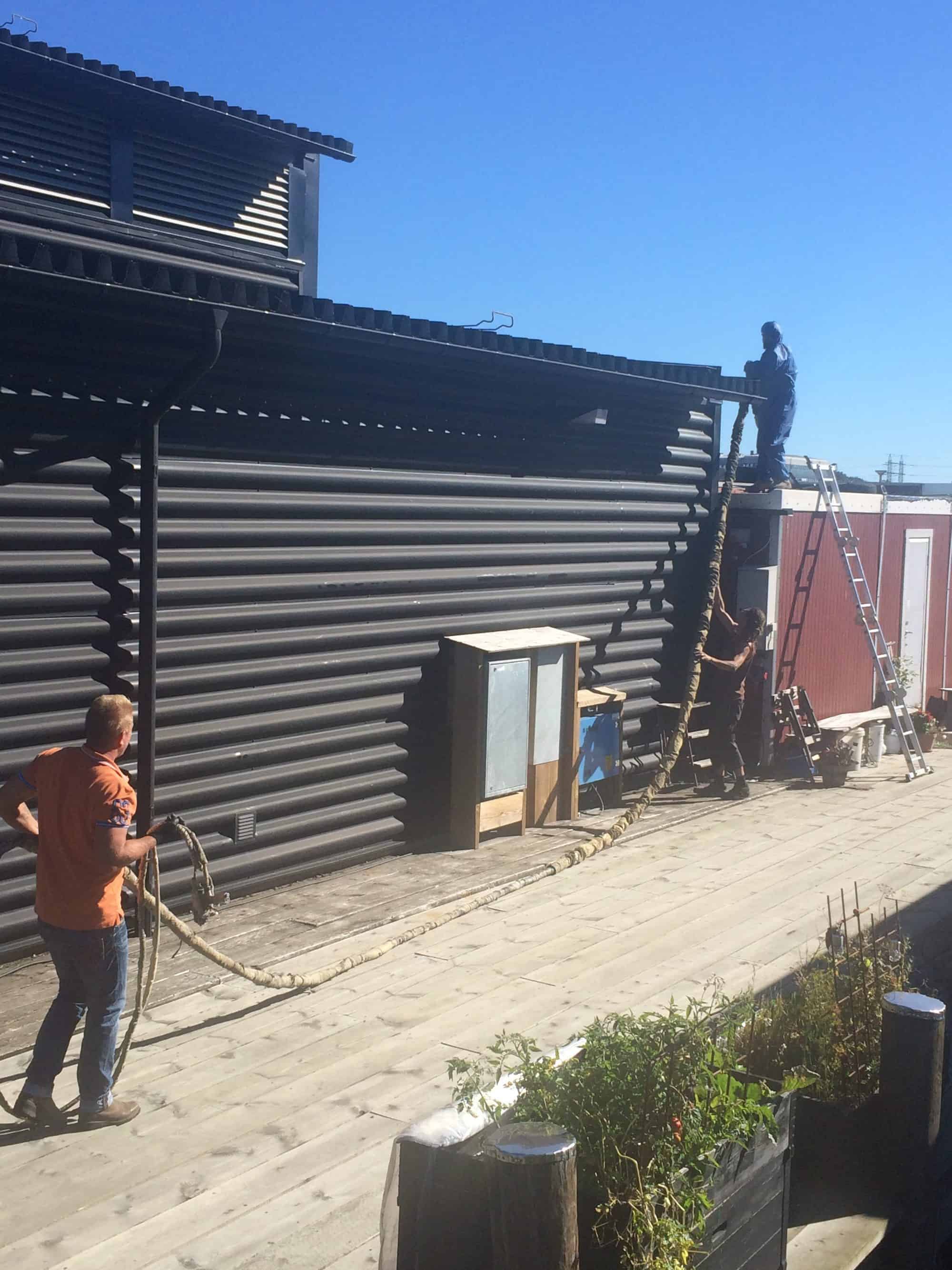 Stefan, Mike and Tony are putting the hose over the shed