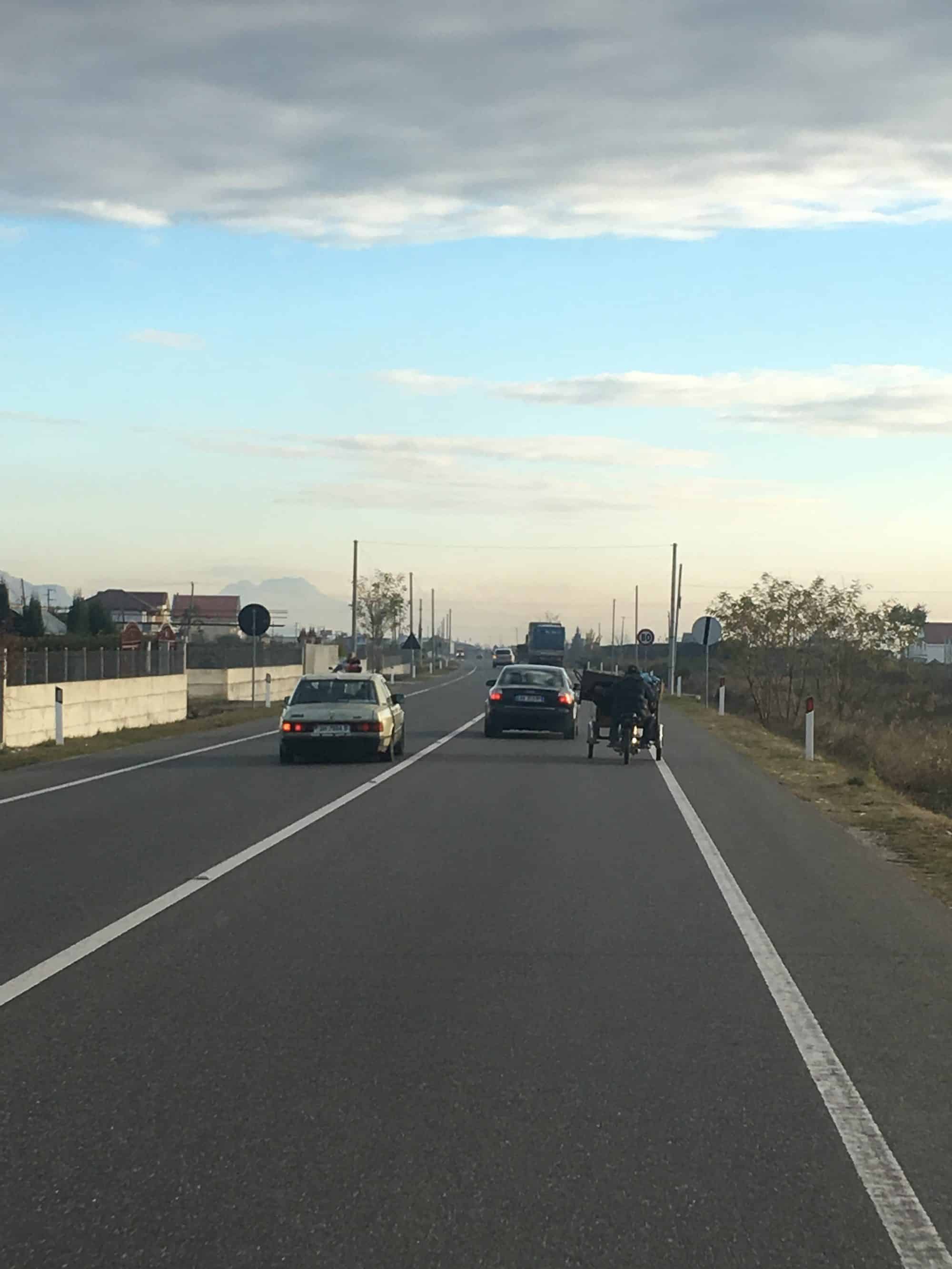 A motorbike with way too much load and Mercedes