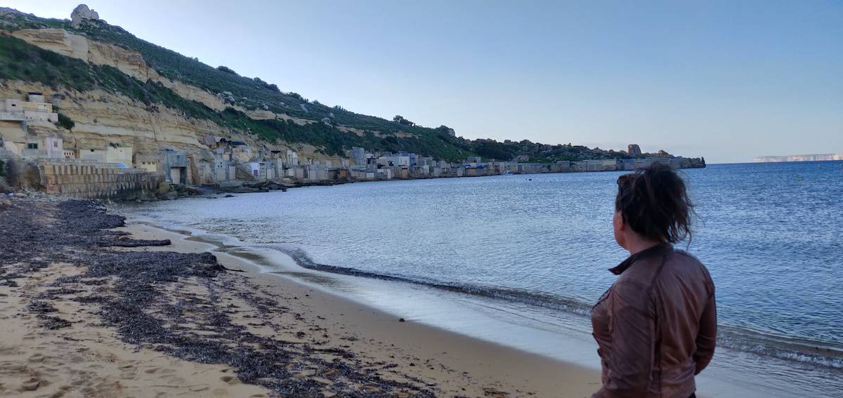 Me at the beach at Gnejna bay, boathouses in the cliffs