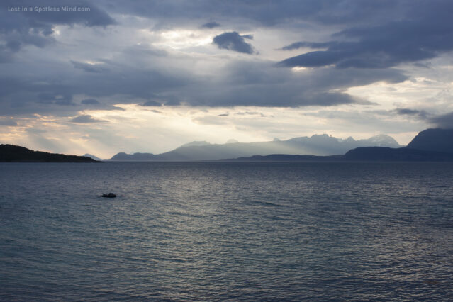 A moody seascape in deep blues and pale golds.