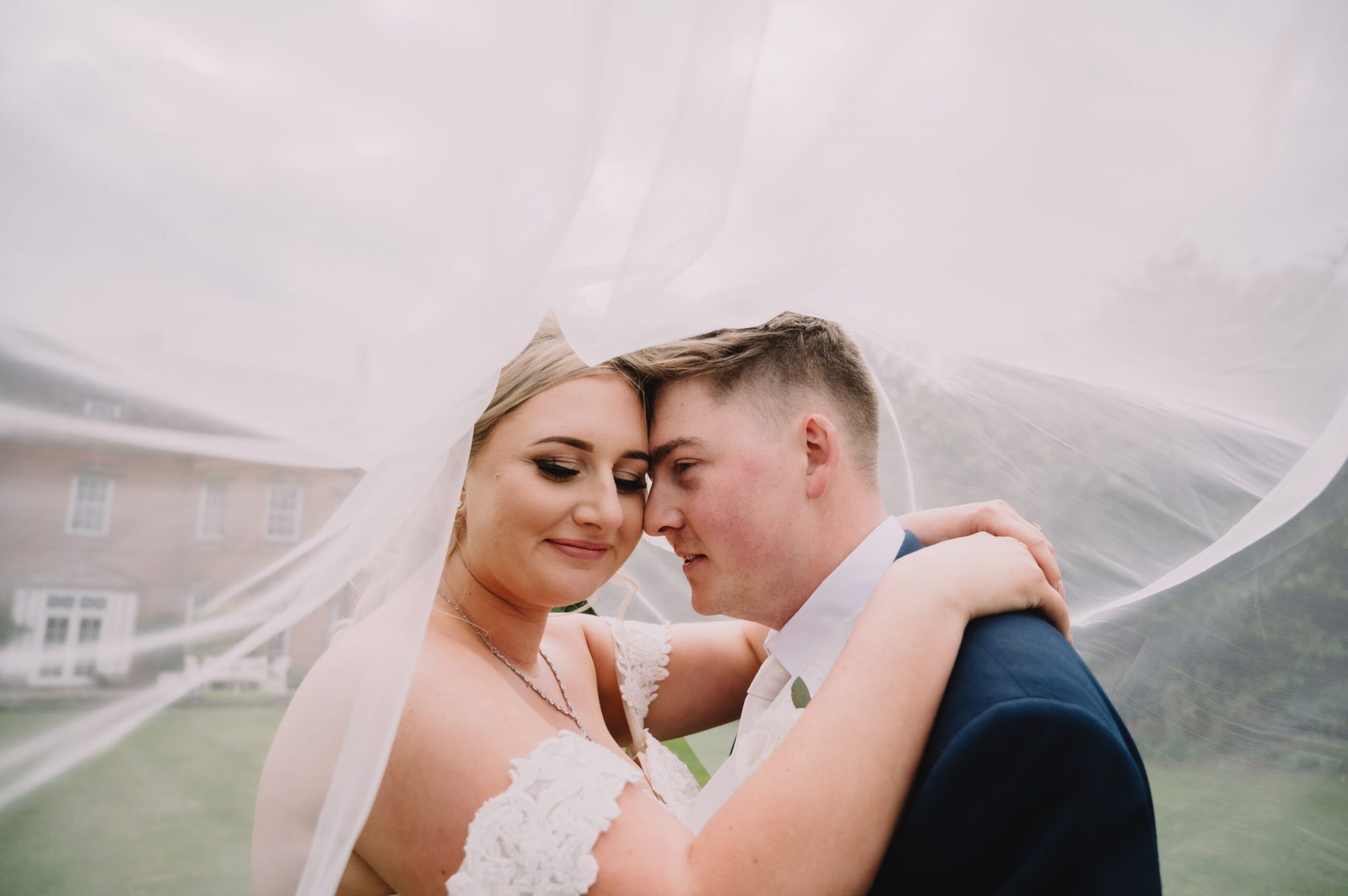 A bride and groom under a veil