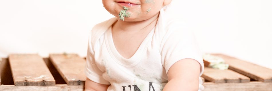 A little boy at his birthday cake smash photoshoot