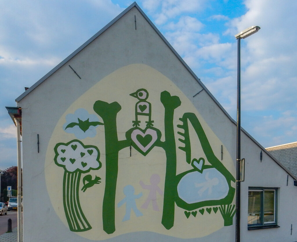 Muurschildering van de omgeving van kinderen. Dicht bij scholen. Klein dier (eekhoorn) om de hoek. Het ontwerp is gemaakt door beeldende kunstdocent Joan Tesser, in samenwerking met leerlingen van het nabijgelegen Prins Willem Alexander Schoolcentrum. Je ziet kinderen en dieren genieten van park het Groene Hart, ingang tegenover muurschildering.