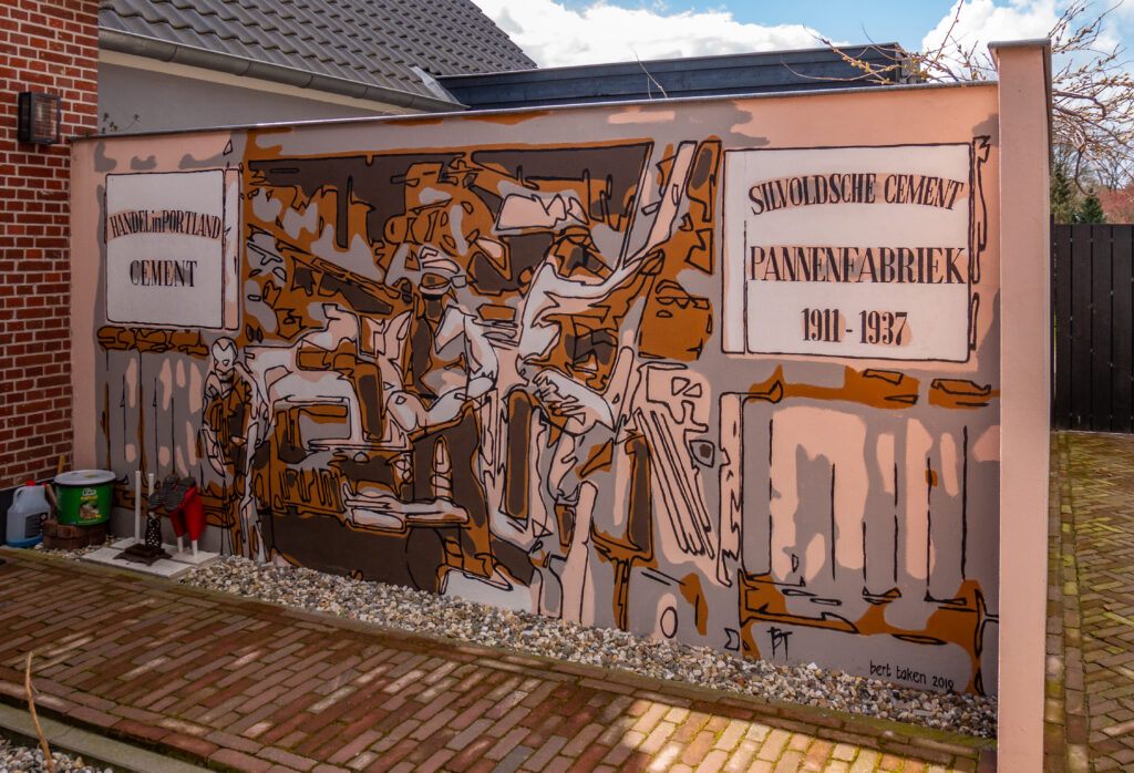 De muur staat op de plek waar dakpannenfabriek Berkelder heeft gestaan van 1911-1937.
Als cementpannenfabriek en handel in portland cement, tussen de geopende deuren van de pannenfabriek waarop links en rechts de reclameborden terugkomen die vroeger boven de werkplaats zaten. Tussen deze deuren is er een inkijkje in de oude fabriek en iemand die de ladder opgaat met een stapeltje dakpannen.