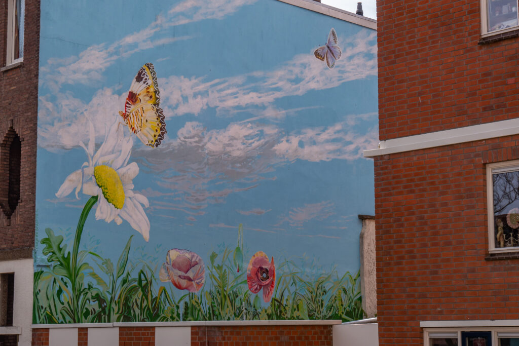 margriet snaterse noemt ze zichzelf een ‘verbindende stadskunstenaar’. Ik vind het een lief en vrolijk voorbeeld van hoe het ook kan. Graffiti oogt vaak een beetje agressief of eng, maar deze mural juist helemaal niet. Het is juist bijna schattig, ondanks de opvallende grootte.