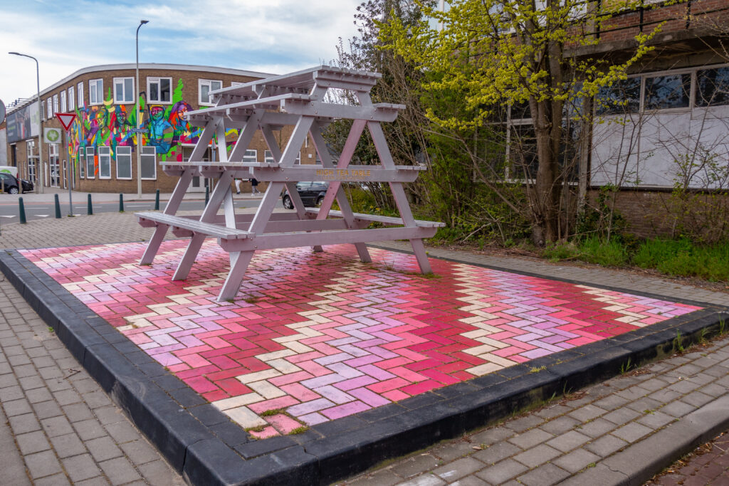 Hight tea anyone?
Grondschilderingen zijn net zo belangrijk! Dario Goldbach schilderde deze grondschildering met levendige kleuren vlakbij de Binckhaven, één van de plekken op de Binckhorst waar zich veel Haagse start ups en ondernemers hebben gevestigd. De schildering en de picknick bank ( ‘High Tea Table’ van Daan den Houter) bieden een mogelijkheid voor de ondernemers om elkaar te ontmoeten!