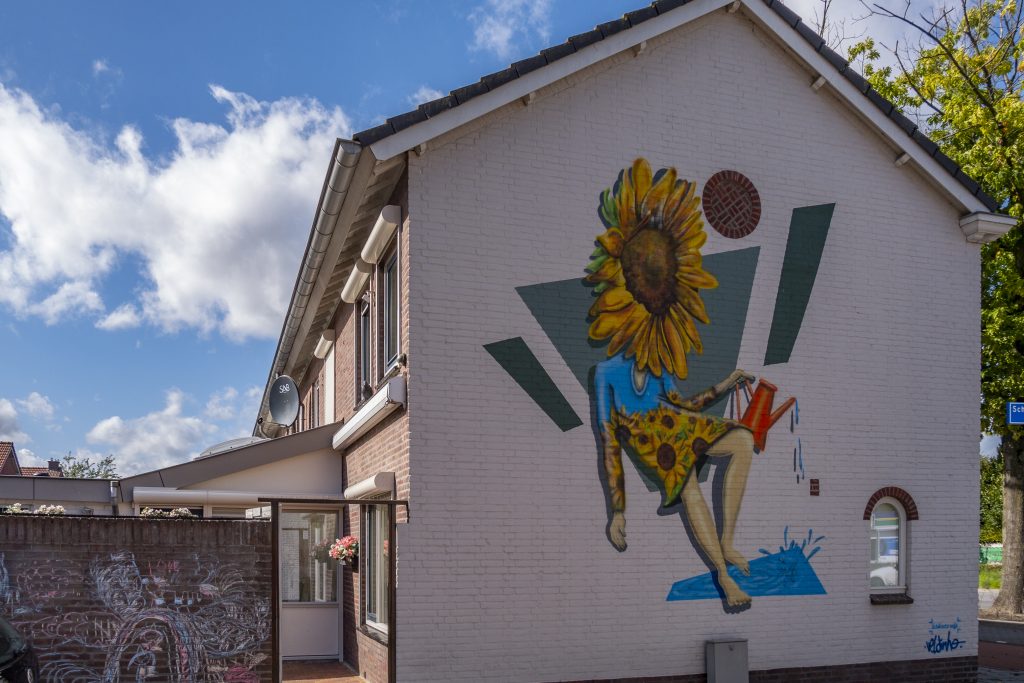 is geïnspireerd op de zonnebloemen van Van Gogh.
Het is een Zonnebloemmeisje met een gieter die zichzelf water geeft en daarmee de cyclus van het leven symboliseert.