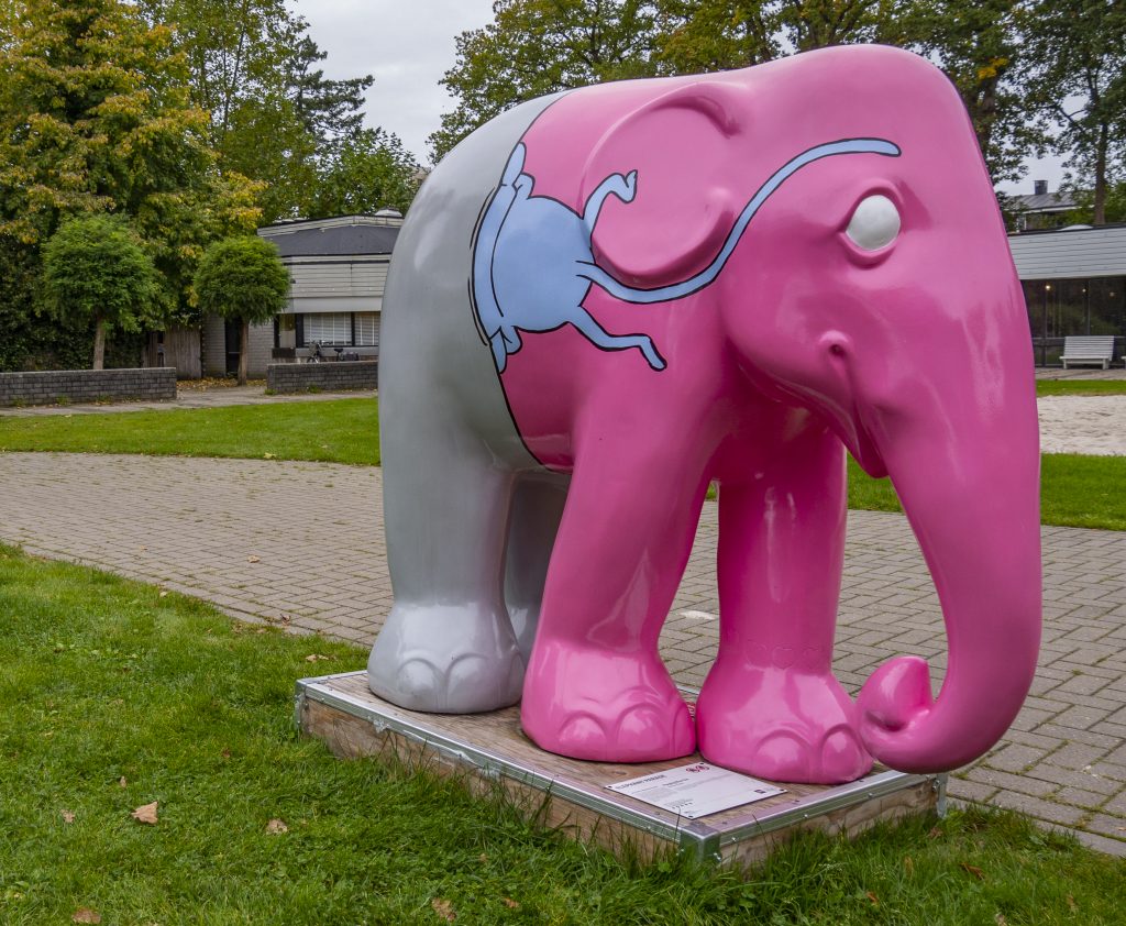 PEEPING BLUE ONE
- Soju Tanaka
Iemand gluurt uit het spleetje van de olifant. Kijkend naar ons. Hij ziet eruit als een olifant, maar er is iets vreemds aan de dag. Echt een olifant? Het maakt niet uit. We zien net een blauw wezen uit de gleuf van de olifant.