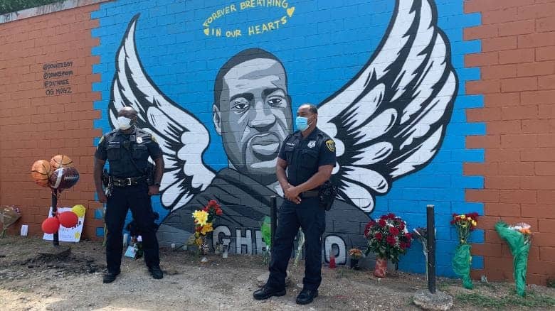 Two police officers pay their respects to George Floyd in Houston.