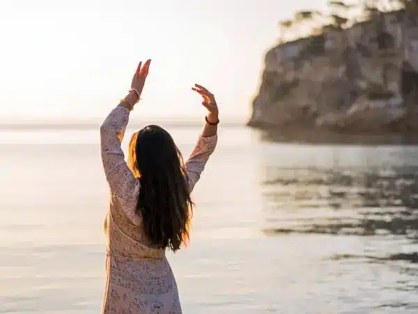 woman doing somatic yoga at the seaside
