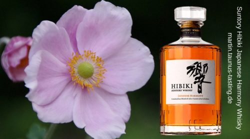 Eine Flasche Suntory Hibiki Harmony, im Hintergrund eine Hibiskusblüte