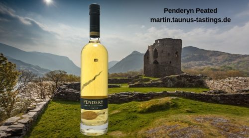 Eine Flasche Penderyn Peated, im Hintergrund eine walisische Landschaft