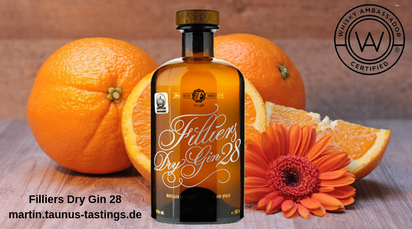 Eine Flasche Filliers Dry Gin 28, im Hintergrund Orangen