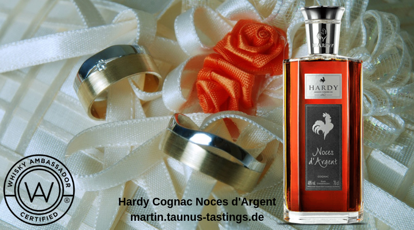 Eine Flasche Hardy Cognac Noces d'Argent, im Hintergrund Eheringe