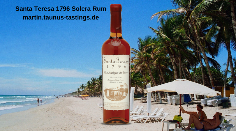 Eine Flasche Santa Teresa 1796 Solera Rum, im Hintergrund ein Strand in Venezuela