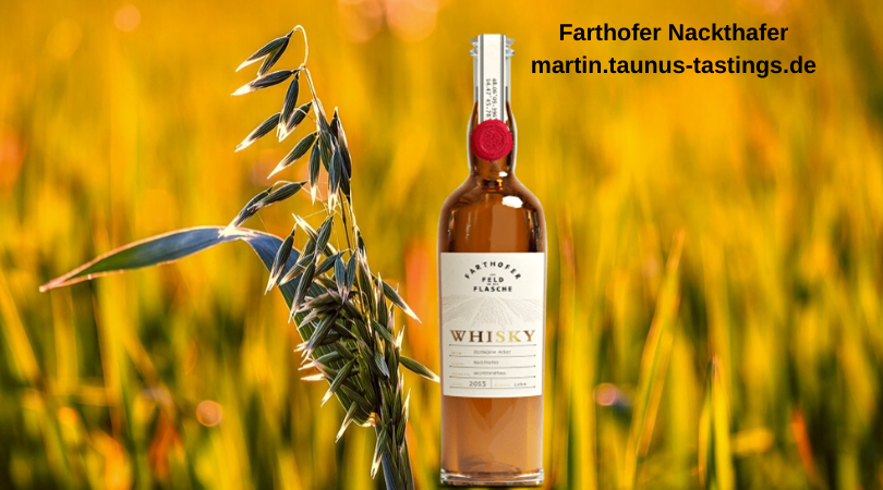 Eine Flasche Farthofer Nackthafer Whisky vor einem Haferfeld