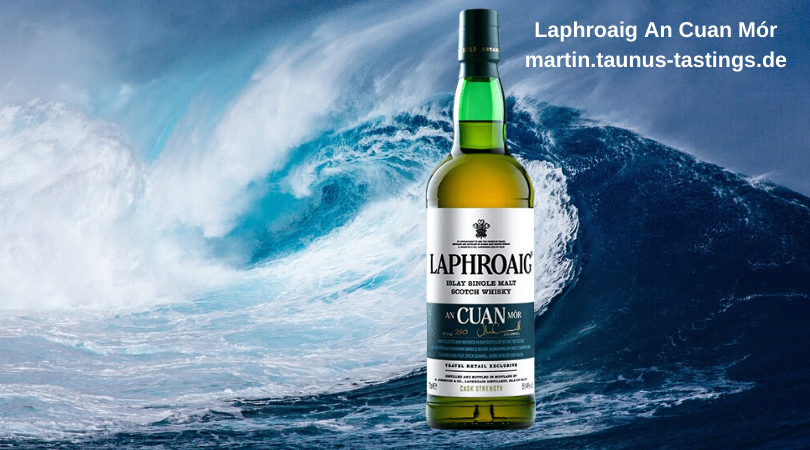 Eine Flasche Laphroaig An Cuan Mor mit dem Ozean und einer großen Welle im Hintergund