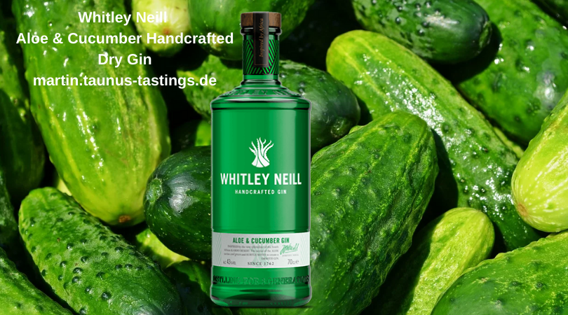 Eine Flasche Whitley Neill Aloe & Cucumber Handcrafted Dry Gin, im Hintergrund Gurken