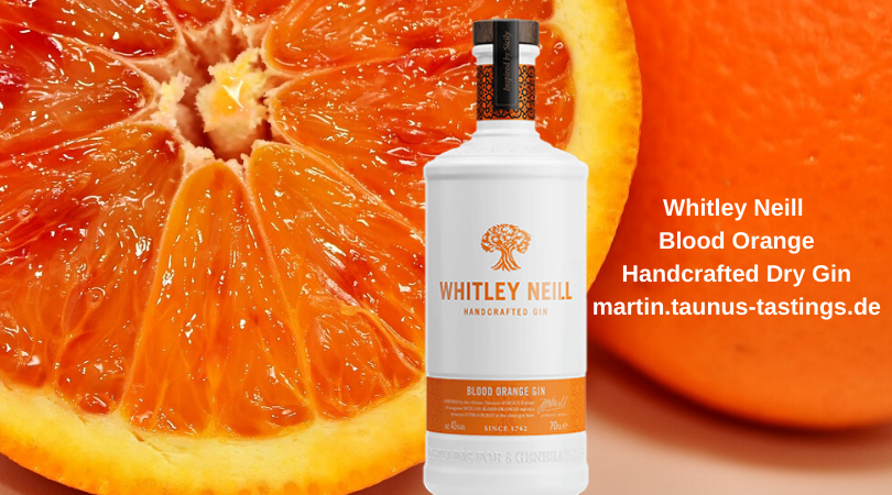Eine Flasche Whitley Neill Blood Orange Handcrafted Dry Gin mit Blut Orangen im Hintergrund