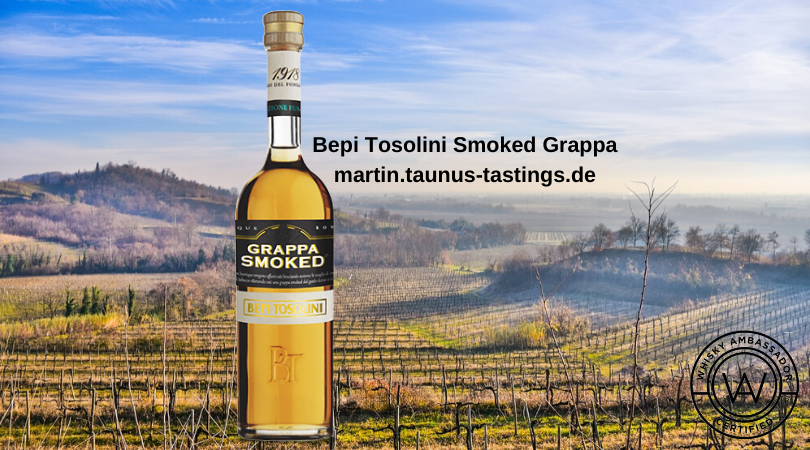 Eine Flasche Bepi Tosolini Smoked Grappa mit Weinbergen im Hintergrund