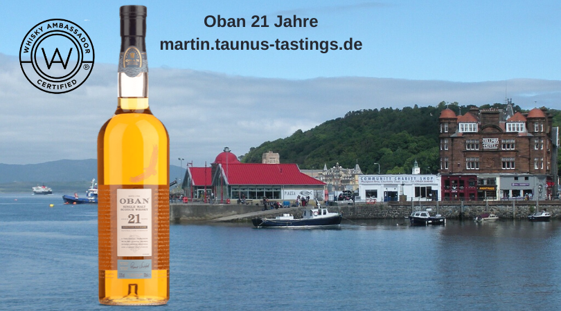 Eine Flasche Oban 21 Jahre mit der Bucht von Oban im Hintergrund