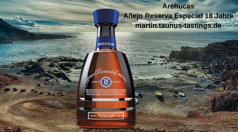Eine Flasche Arehucas Añejo Reserva Especial 18 Jahre vor einem Strand auf den Kanaren